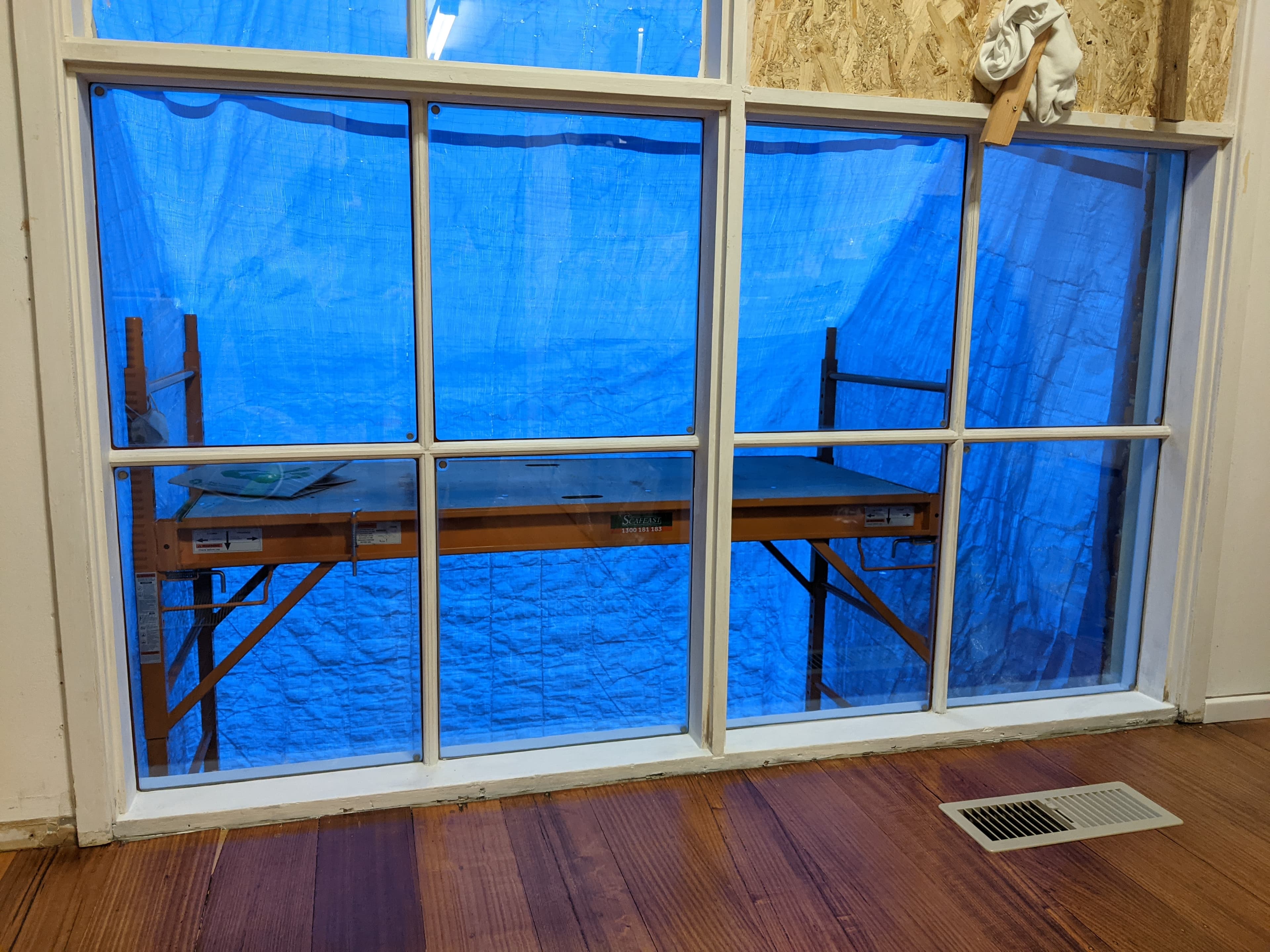 Interior view of the Dalpura colonial window with blue construction sheeting outside