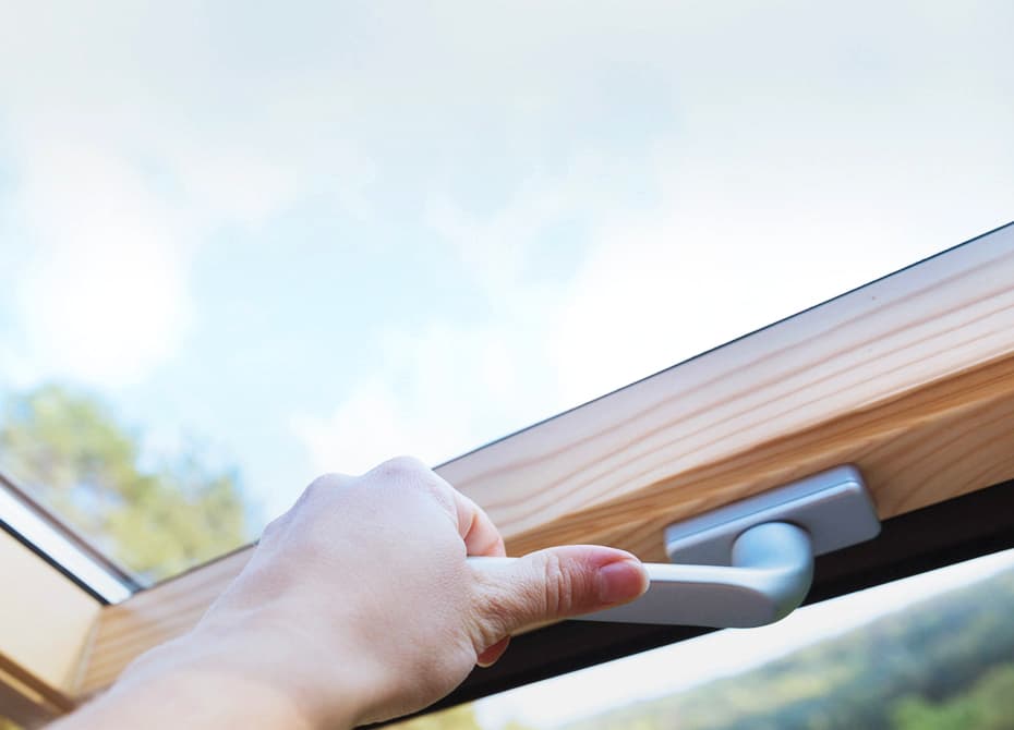 Timber roof window being opened to bring light into a room