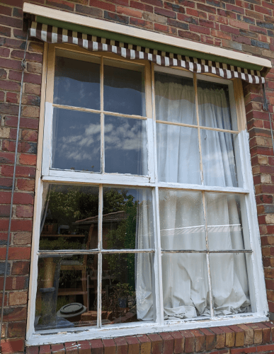 Existing painted timber sash window in a brick wall