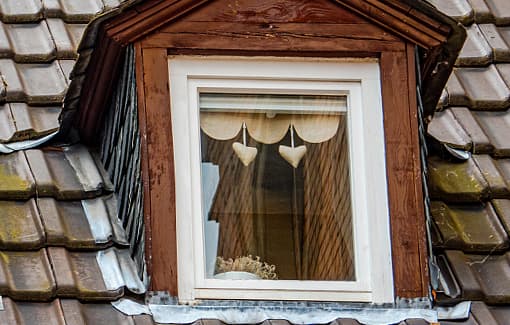 Traditional timber window set into a shingled roof